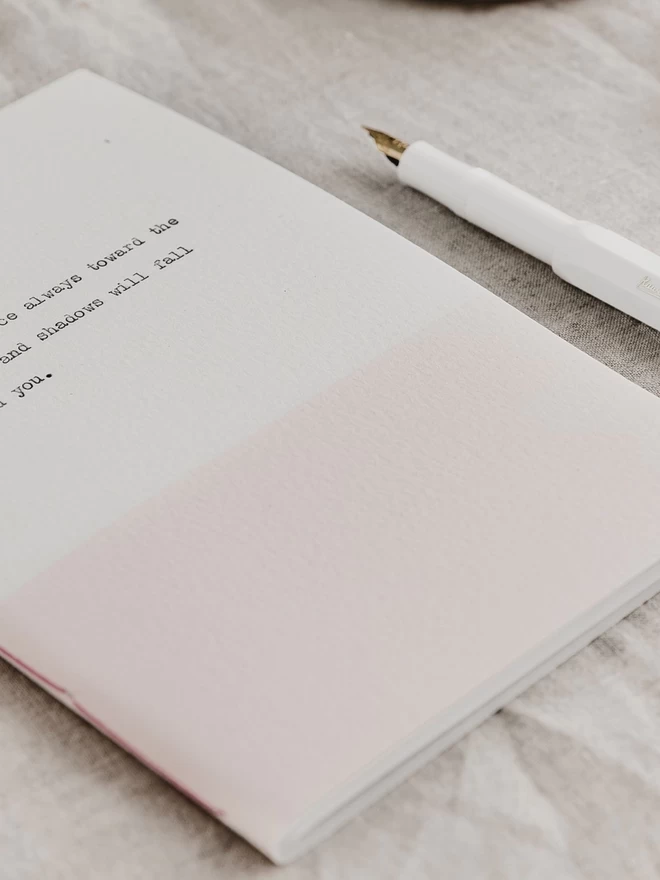 pale pink and white personalised notebook with typed text on the cover