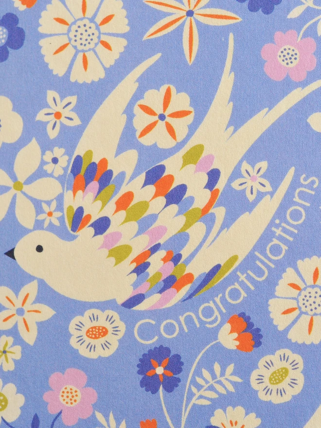 purple card with oval design with flowers and birds and 'congratulations' text