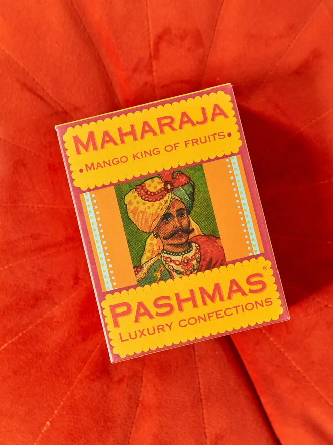 box of pashamas mango sweets on red cushion
