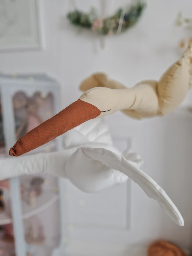 Flying Swan Hanging Decoration, a hanging beige swan decoration, suspended in a child's bedroom. 