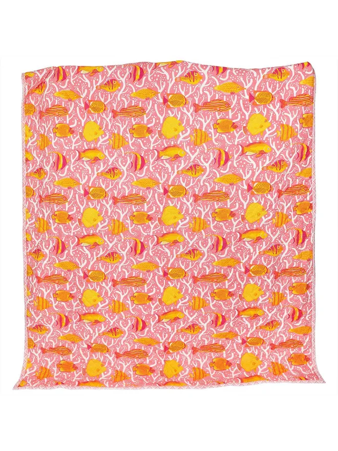 Pink Coral Reef Quilt, a pink quilt with a yellow and orange tropical fish print, open on a white background.