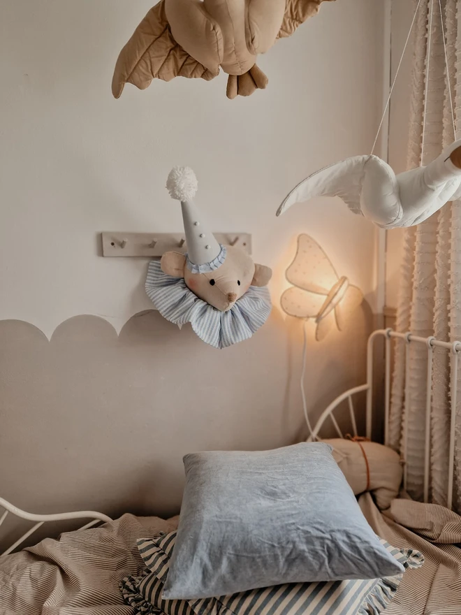 Bear Head Nursery Decoration, a bear decoration sitting against a wall in a child's decorated bedroom. 