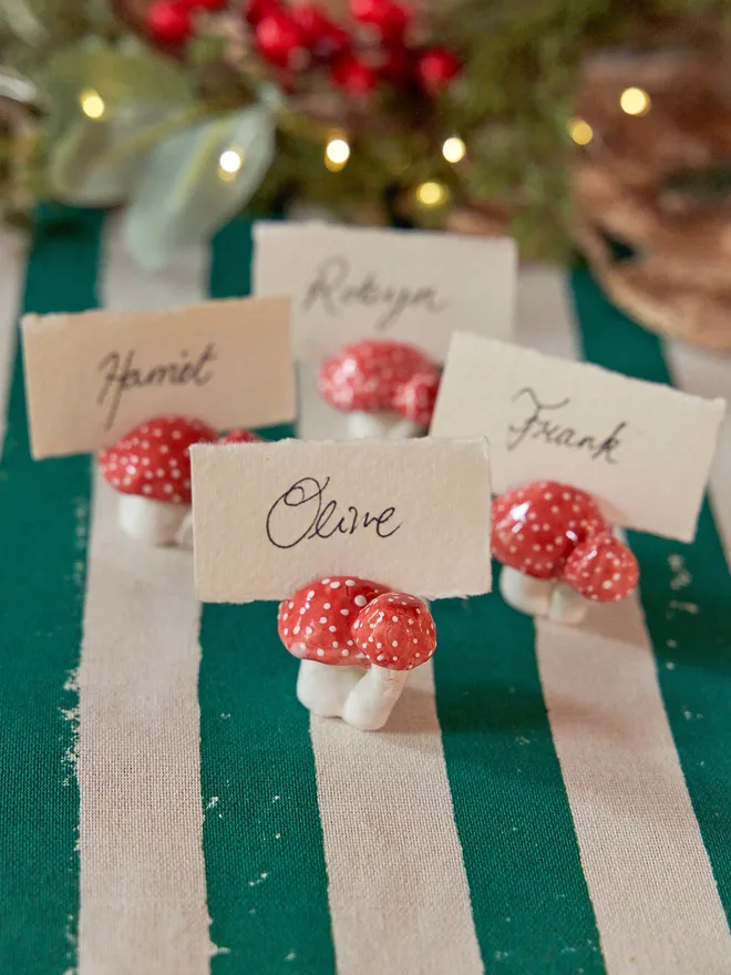 A Toadstool name card holders red and white places on a chritsmas set up table 
