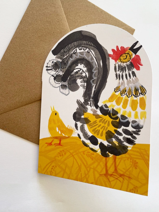 Esther Kent illustrated greeting card showing black, yellow and red stylised cockerel on an arch-shaped card