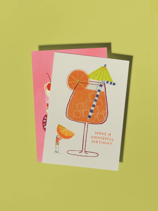 Aperol Spritz Cocktail Card with cocktail mbrella, orange slice and character interacting with the glass holding up an orange slice