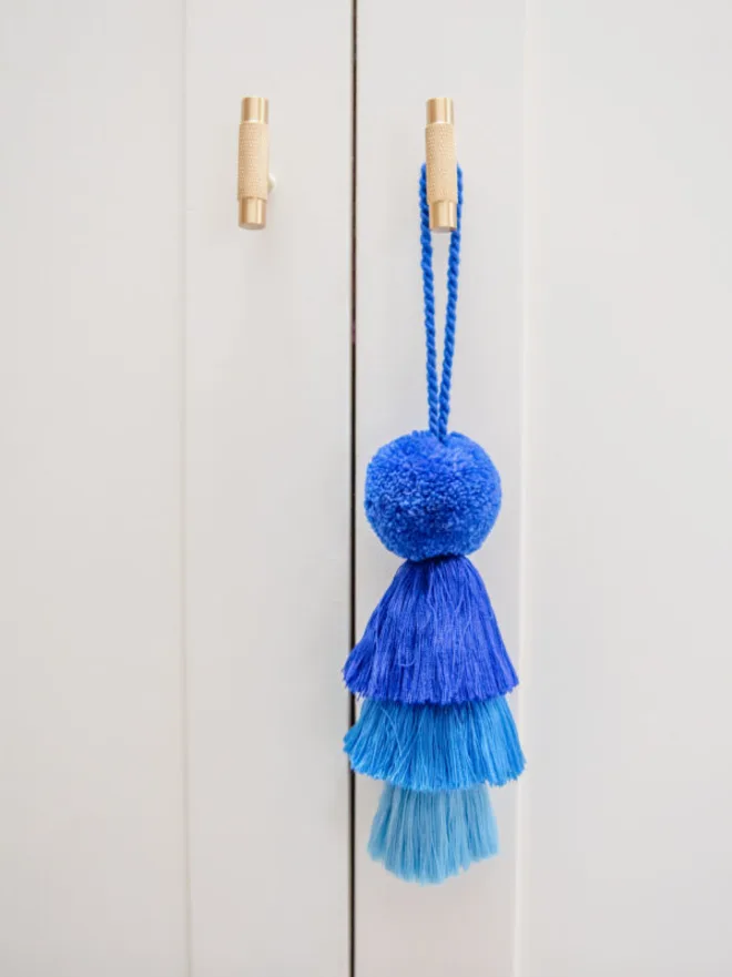 pom pom and tassel swag hanging decoration. a hanging decoration in shades of blue.