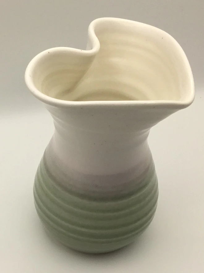 porcelain heart shaped vase. a vase with a heart shaped mouth, glazed white on the top half and green on the bottom.