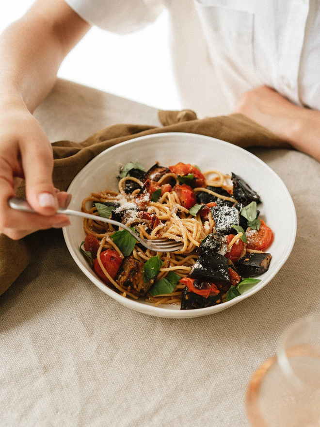 'milk' handcrafted stoneware bowl. a white serving bowl holding tomato pasta.