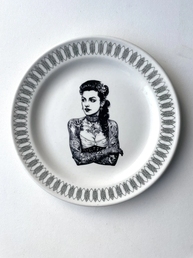 a vintage bone china plate with ornate border has a vintage Tattooed victorian lady in the centre