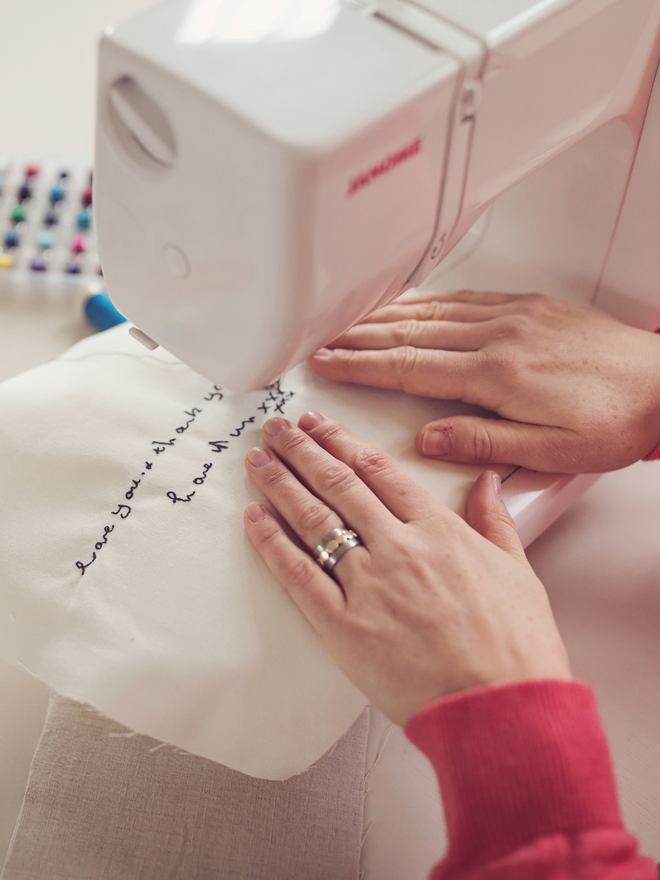 hands sewing freehand machine embroidered handwriting