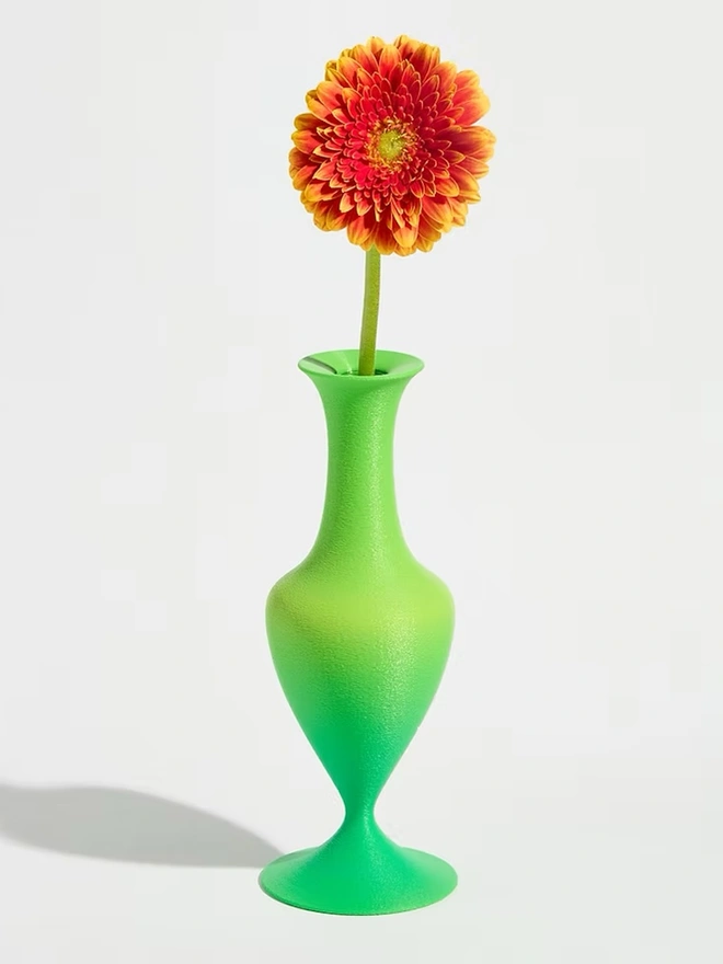 3d printed vase in green stripes with bright pink flower