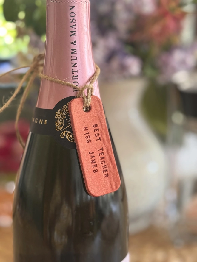 Pink leather teacher label on a bottle of champagne