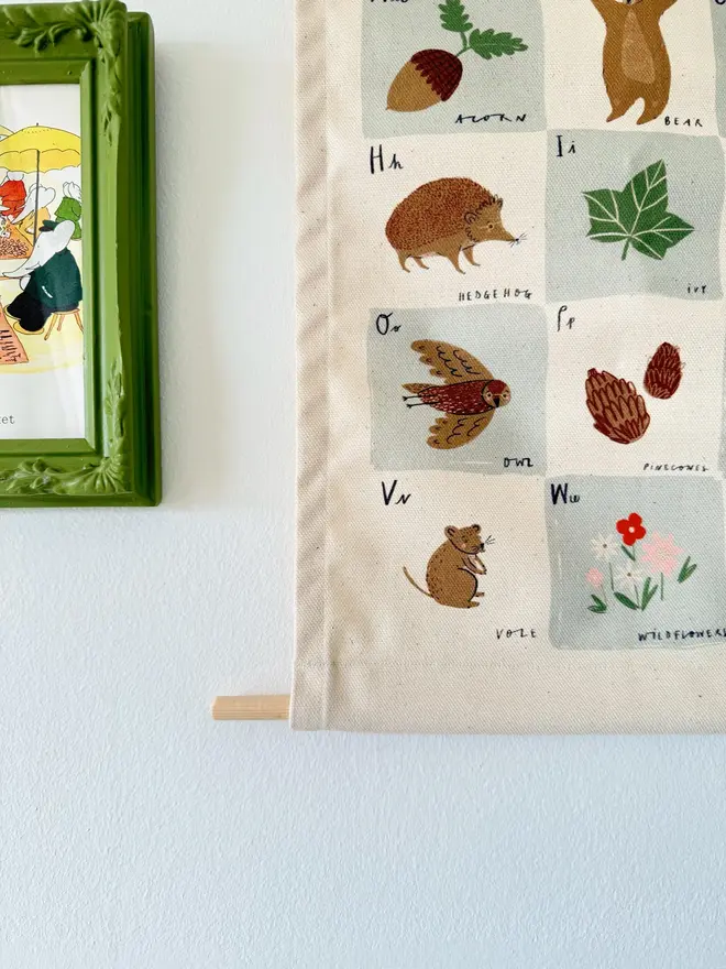 Woodland Alphabet Fabric Banner, hanging on a white wall. 