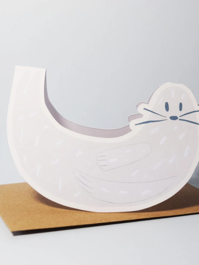 Cut out card of a seal on top of an envelope