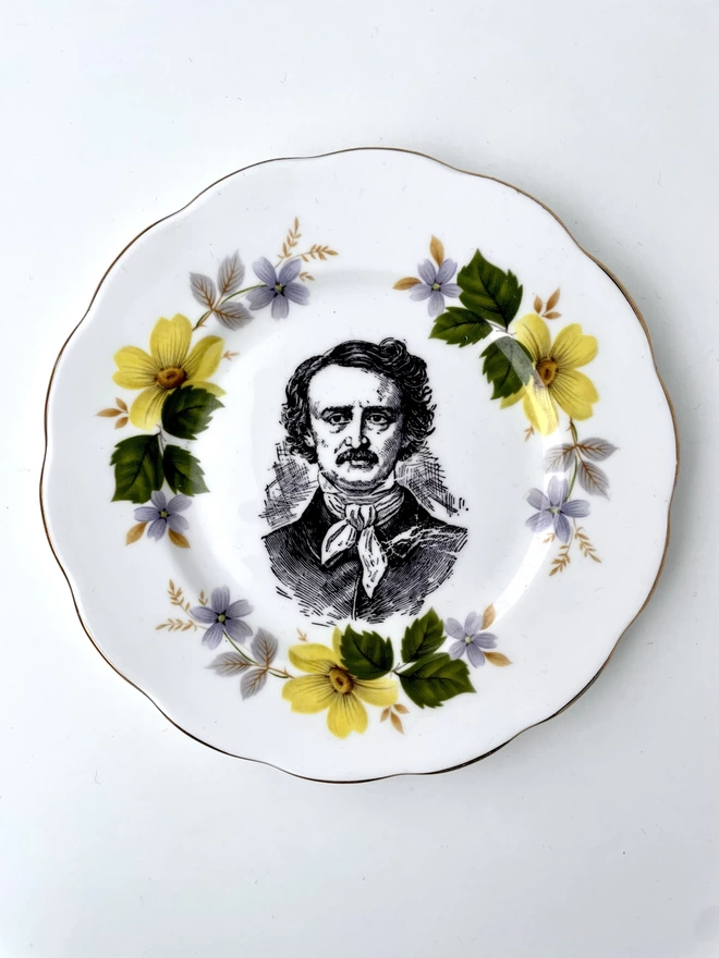 vintage plate with an ornate border, with a printed vintage illustration of Edgar Allen Poe in the middle 