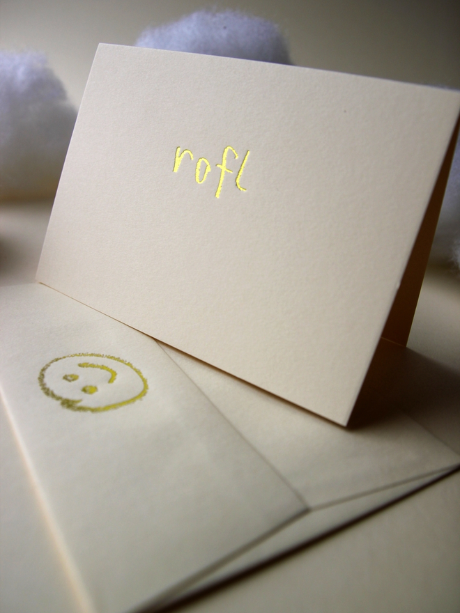 sandy coloured card with rofl short for 'roll on floor laughing' hand foiled in kids hand writing