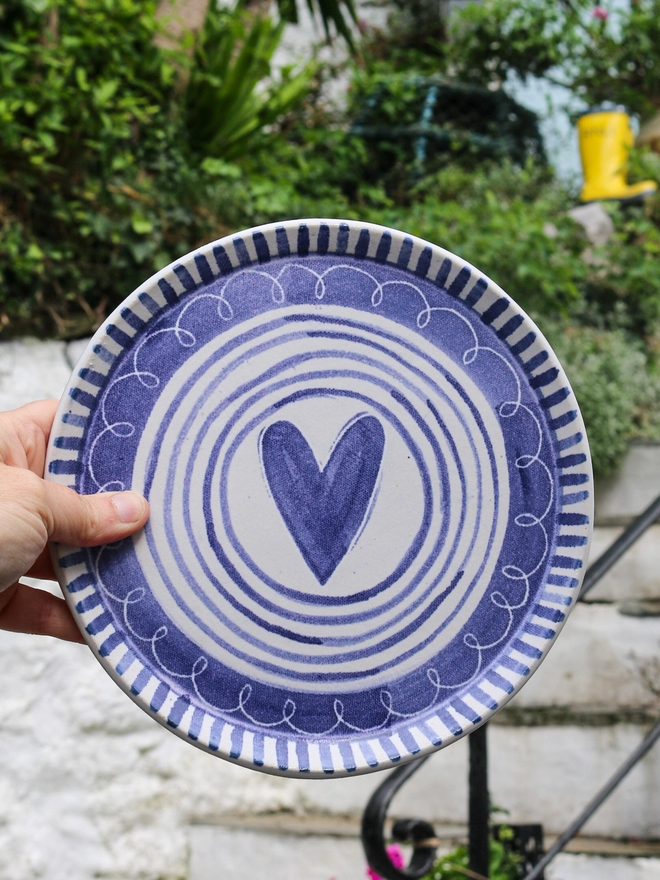 stripy heart plate in front of cottage