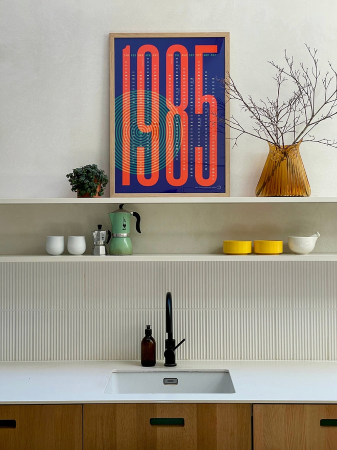 Vertigo Personalised Date Poster on a shelf. A poster in sapphire. Kitchen setting.