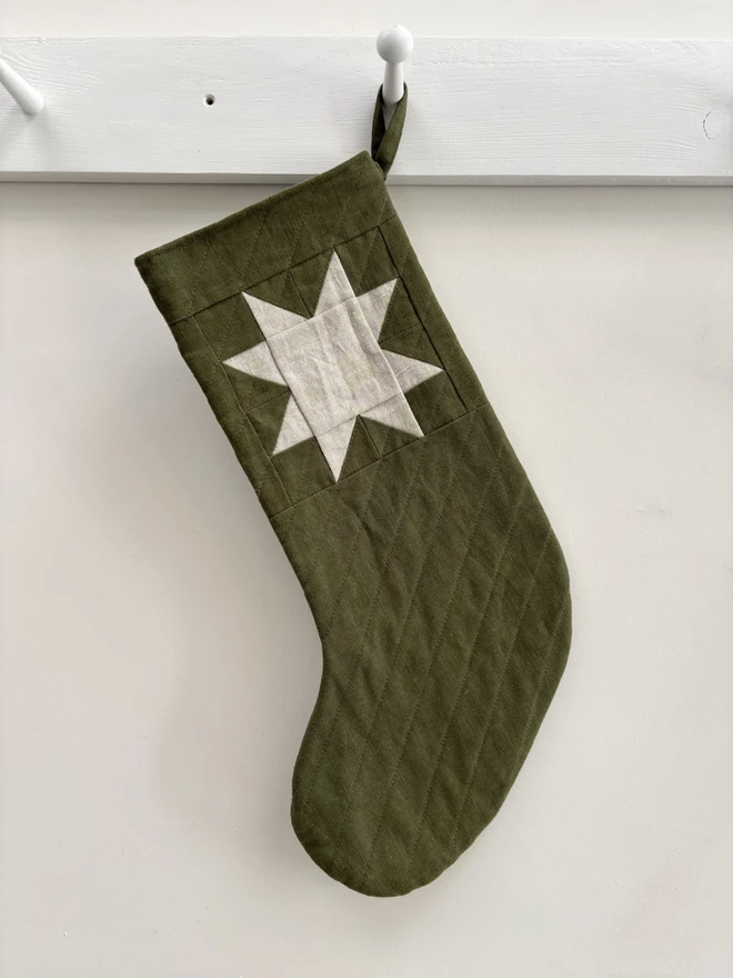 Medium Star Quilted Linen Christmas Stocking. A Green Linen Quilted Chirstmas Stocking with Natural Linen Patchwork Star Detail.