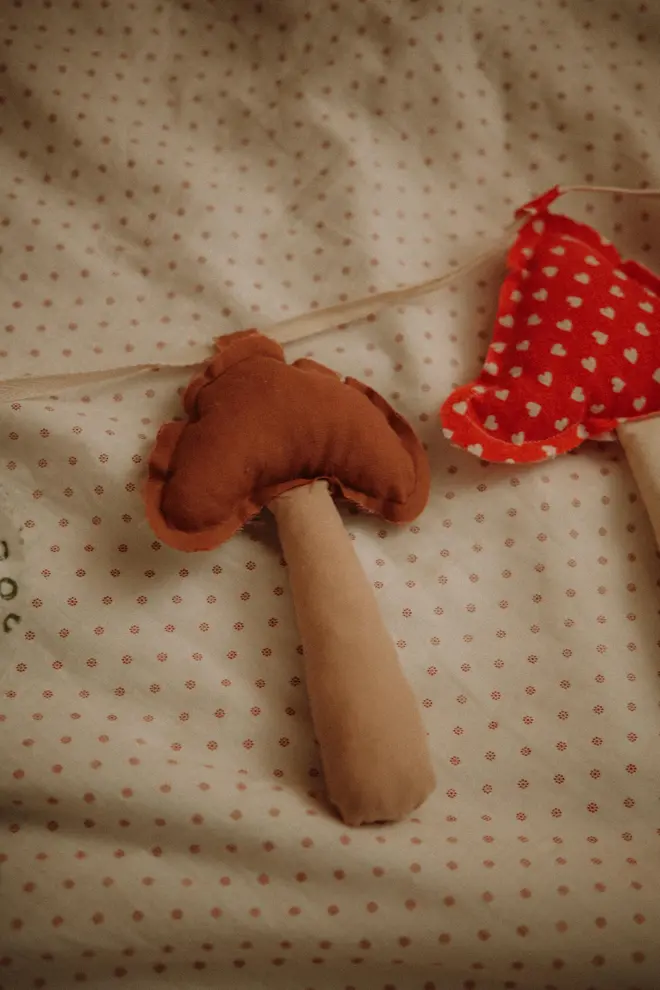 Mushroom Garland DecorationMushroom Garland Decoration, a mushroom garland sitting on a child's bed. 