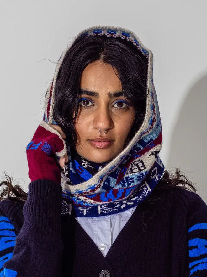 Model is wearing the fairisle loop scarf in klein with claret feminist mittens and our navy Do No Harm cardigan 