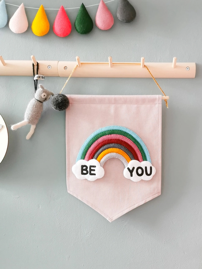 Be you rainbow lilac banner hung up on a peg rail