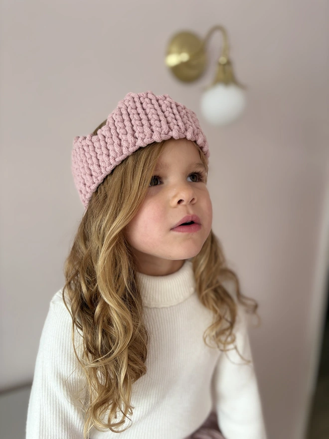 a little girl with a crochet christmas crown on