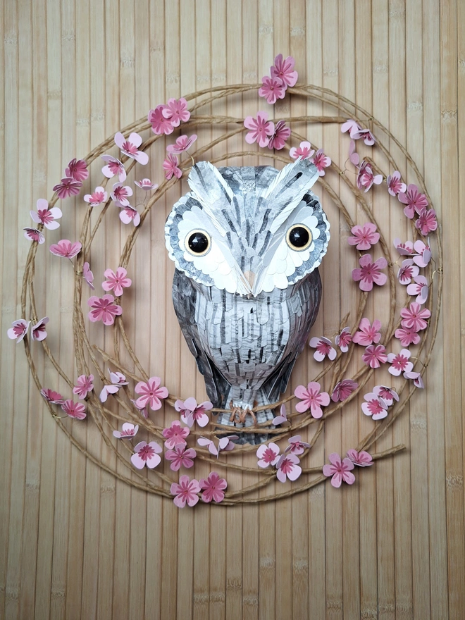 Handmade paper sculpture floral wreath featuring pink tree blossom and a large white faced owl sculpture
