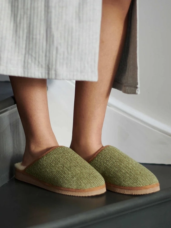 Women's Lambswool & Sheepskin Slippers, a person wearing a pair of colourful slippers indoors. 