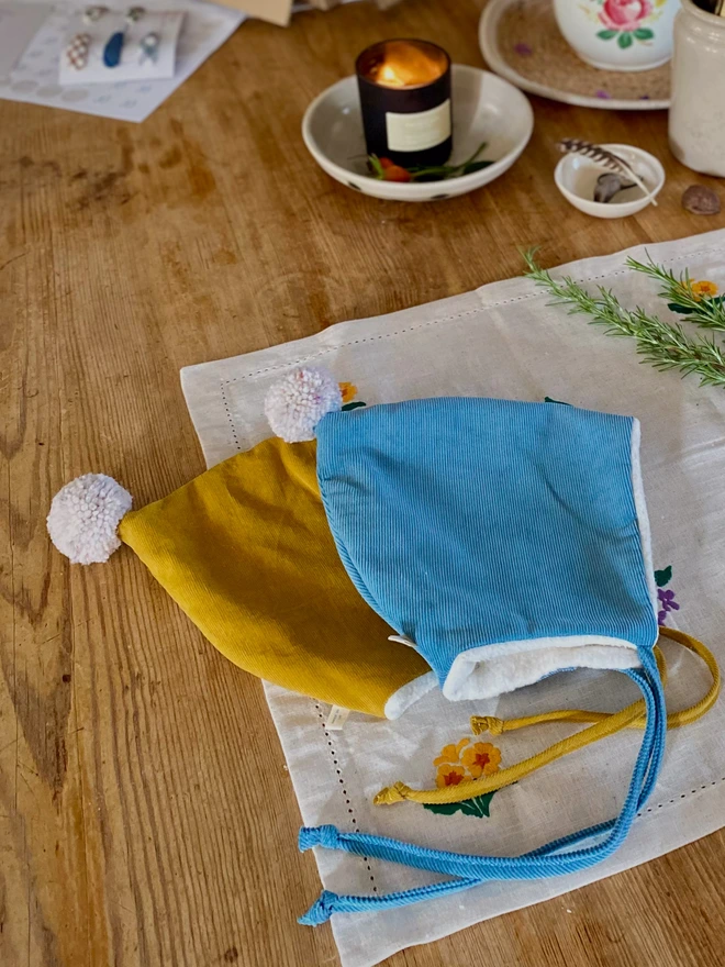 two baby hats being wrapped ready to send