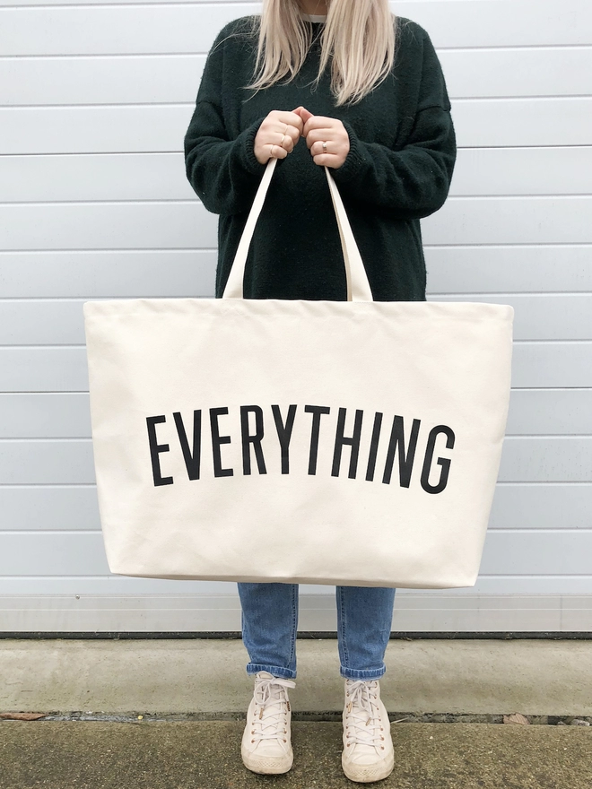 Model carrying the Everything oversized tote bag in natural canvas