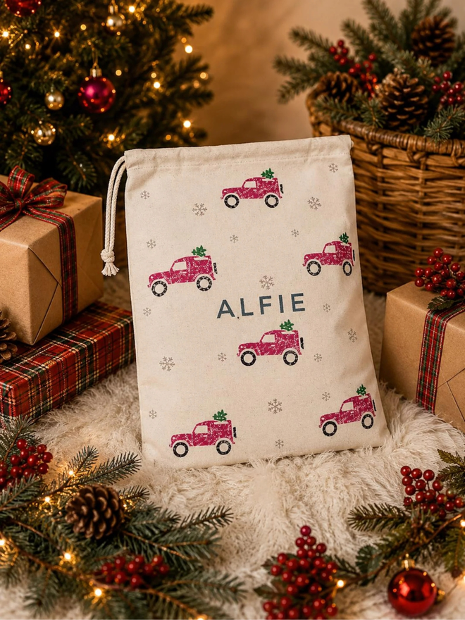 personalised drawstring christmas sack. a drawstring bag with printed christmas motifs and a personalised name.