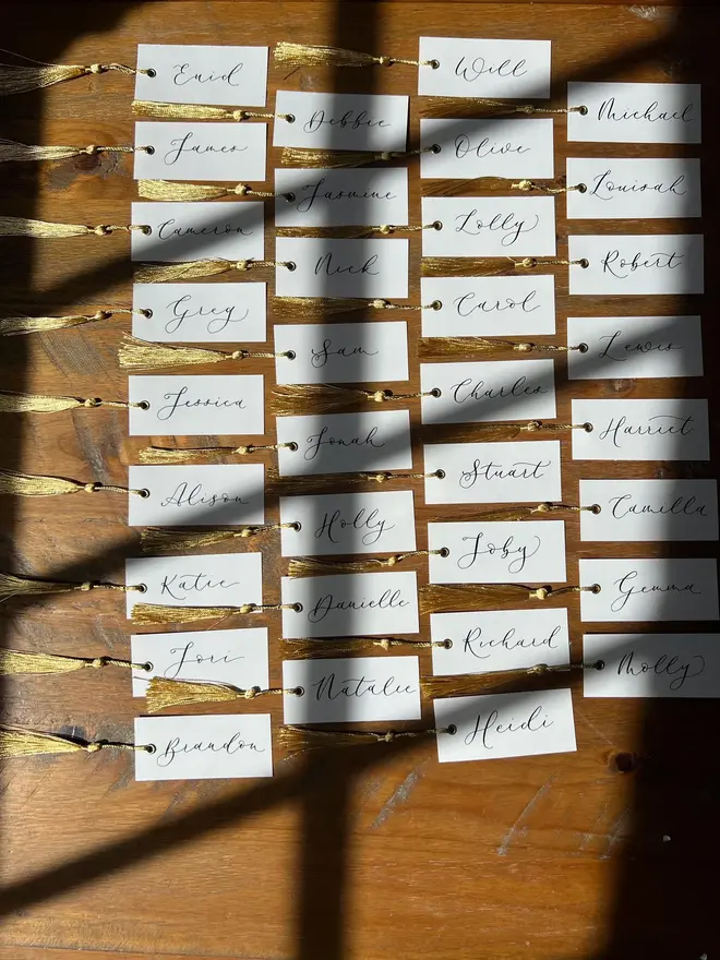 Personalised Calligraphy Wedding White Place Cards, white place cards with ivory and gold tassel. 