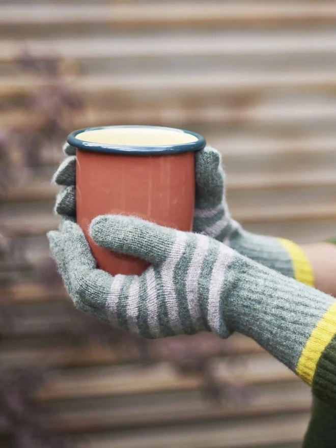 Women's Lambswool Gloves, a woman wearing a pair of colourful gloves outdoors. 