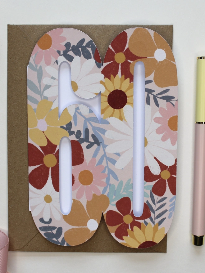 floral 60th birthday card. card shaped like 60 adorned with illustrated flowers.