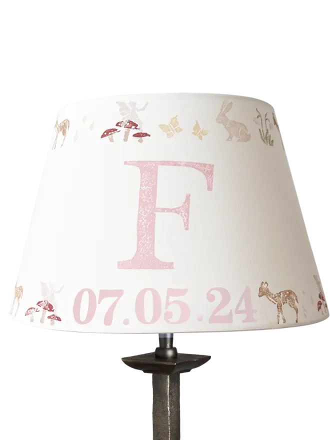 Studio Zef personalised woodland animals lampshade, a pink and cream empire lampshade featuring rabbits, deer, butterflies , fairies and mushrooms, designed as a pretty lampshade for kids bedroom décor.