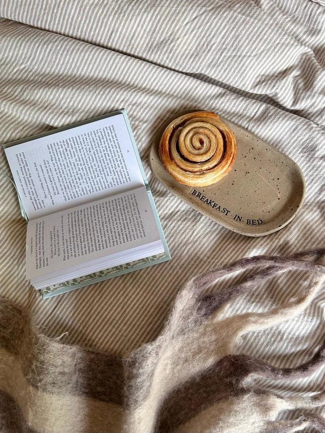 ceramic plate and book on a bed