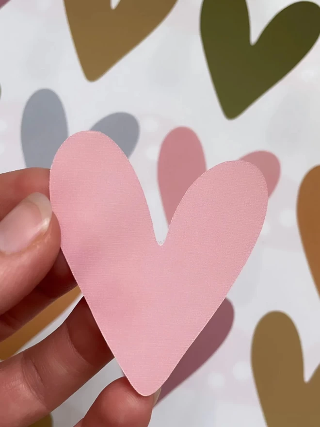 Pink heart shaped fabric wall sticker in hand