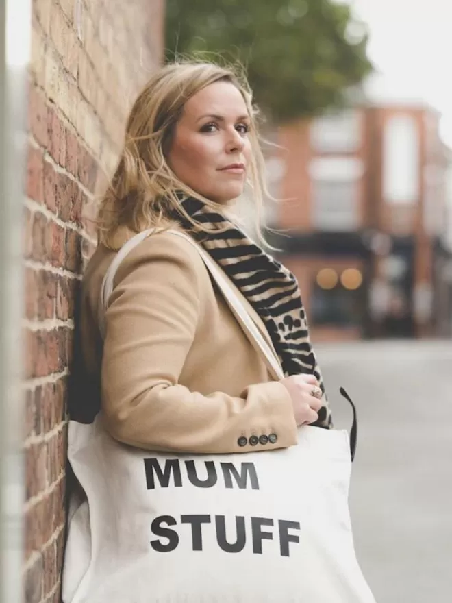 mum stuff natural canvas tote bag modelled by a woman leaning against a brick wall