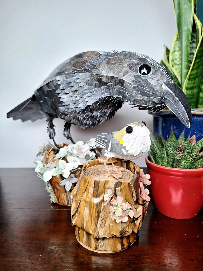 Two birds on tree stumps paper sculptures