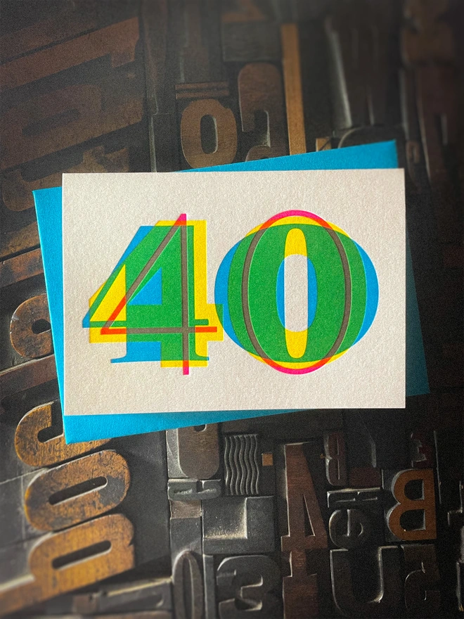 Contemporary handmade letterpress 40th birthday card featuring a bold oversized "50" in a vibrant typographic design. Printed using overlapping cyan, magenta and yellow inks to create striking secondary colours with a deep tactile letterpress impression. Individually hand printed on premium 350gsm GF Smith Colorplan card and paired with a high-quality 135gsm GF Smith Colorplan envelope in a complementary colour. Produced on a beautifully restored 1915 Arab Crown Folio press.