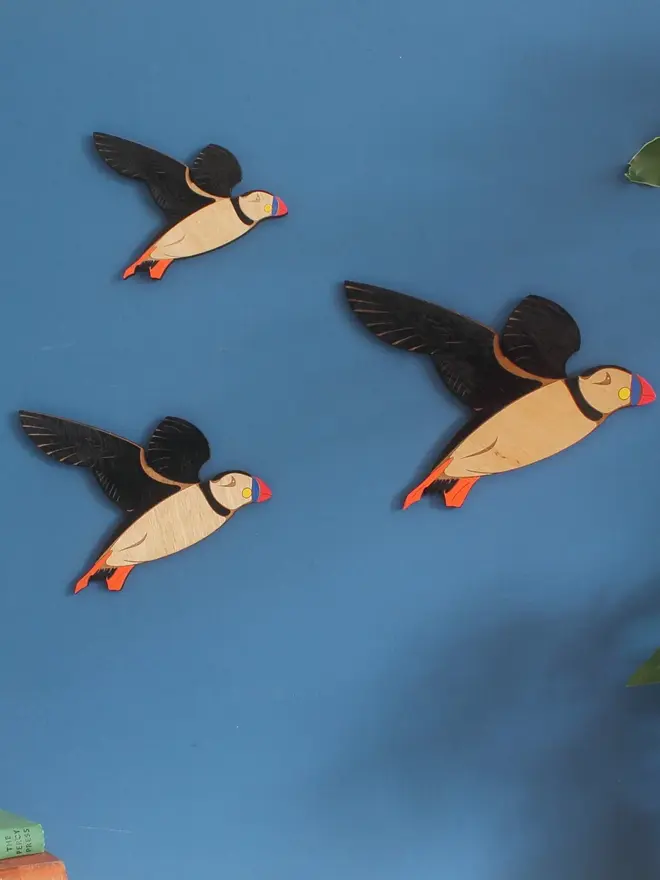 Flying Wooden Wall Puffins (Set Of 3), group of flying wooden puffins hanging on wall. 