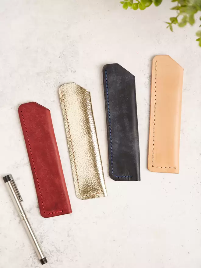 A selection of handmade leather pen holders in different colours.