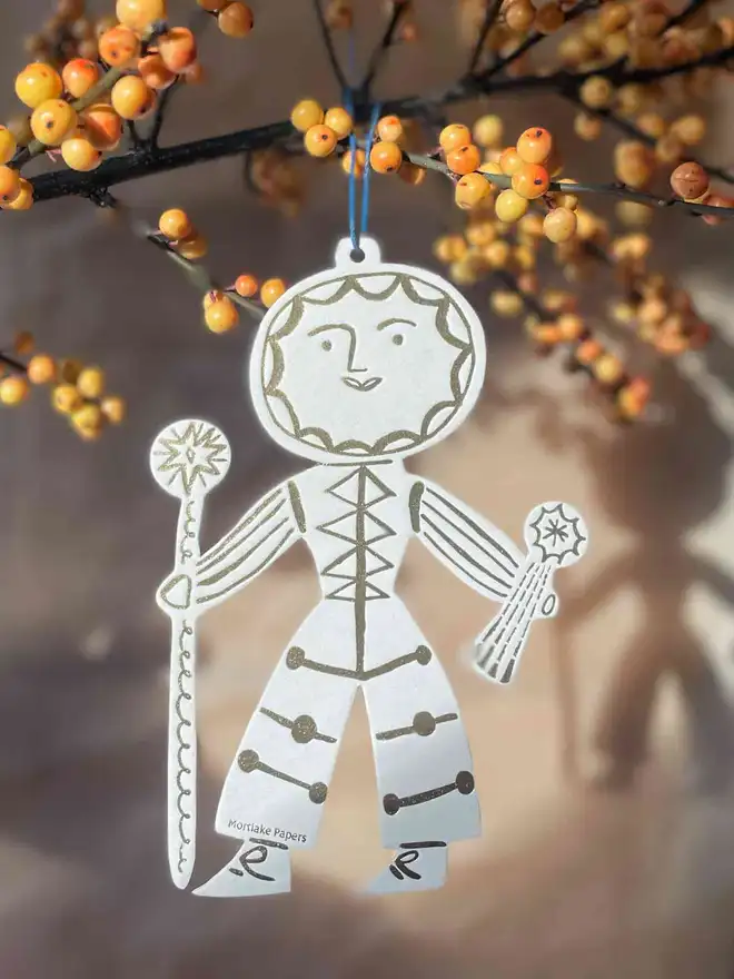 sun folk christmas tree decoration hanging off branch