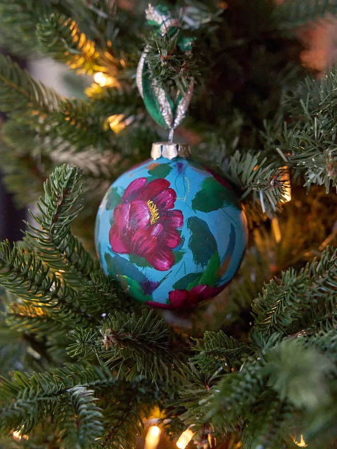 Unique hand-painted ceramic floral bauble featuring red peony flowers on a blue background