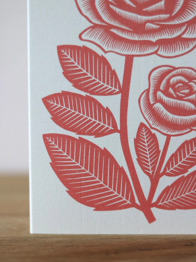 A greetings card with a red rose design based on an original linocut print