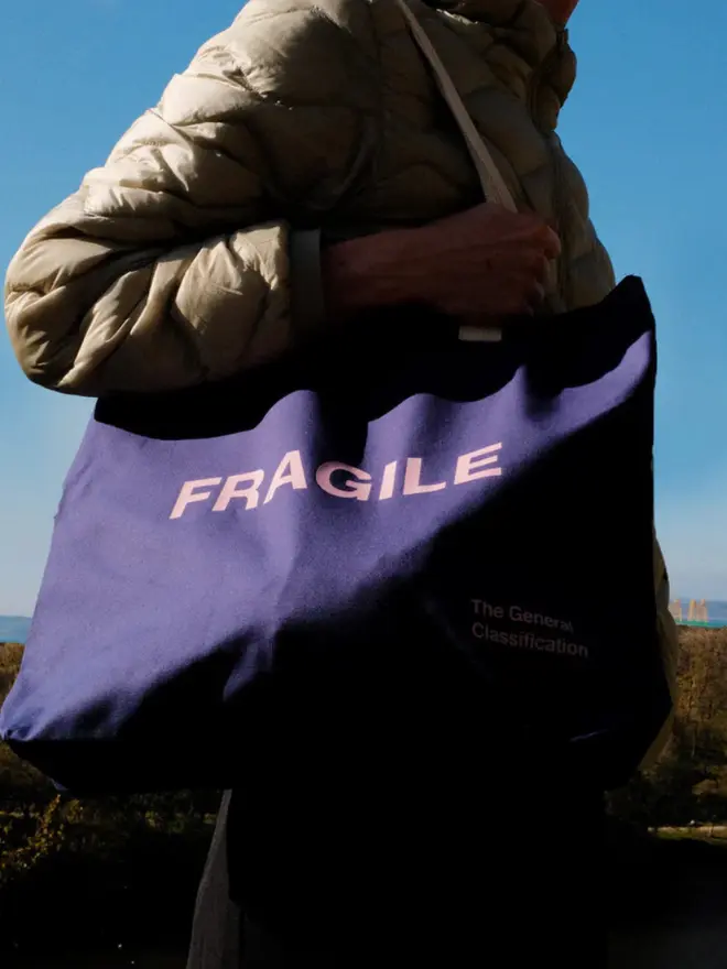 'Fragile' Oversized Tote Navy, being worn. 