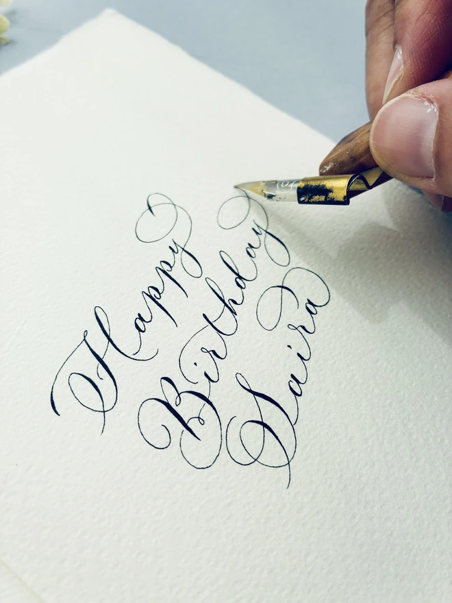 close up calligraphy being written on a birthday card