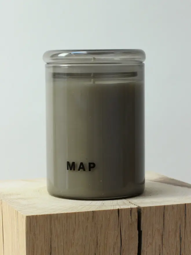 rest aromatherapy candle and home fragrance spray set. candle photographed on wooden surface.