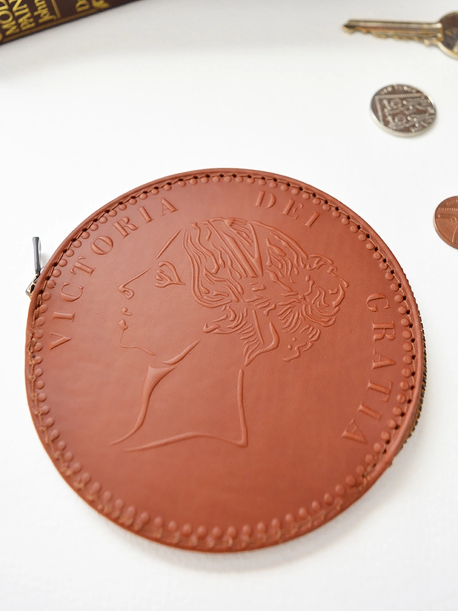 a tan leather coin purse with queen Victoria's head